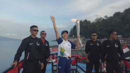 ARTIS Olivia Zalianty memegang obor Asian Games 2018 di Pantai Bebas Parapat, Danau Toba, Simalungun, Rabu (1/8/2018). (Foto: Pribadi)
