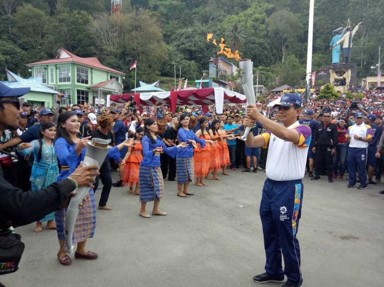 BUPATI Simalungun, JR Saragih menerima obor Asian Games 2018 dengan diiringi tarian persembahan tor-tor Haroan Bolon di Pantai Bebas Parapat, Danau Toba, Simalungun, Rabu (1/8/2018)