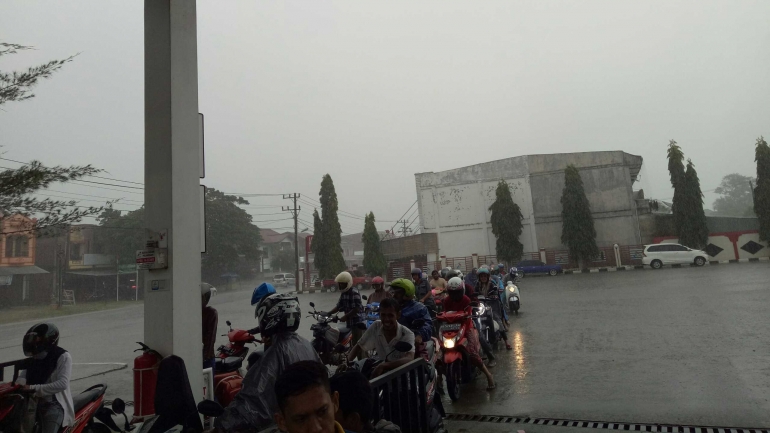 Para pemudik yang menggunakan sepeda motor sedang mengantri untuk mengisi BBM di SPBU Aneuk Galong Kecamatan Indrapuri Kabupaten Aceh Besar ditengah guyuran hujan lebat yang terjadi sepanjang hari ini, Selasa 21 Agustus 2018. (Dokumentasi Pribadi) 