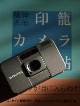 Kamera Fuji Tiara dan buku dengan tema kamera yang sama di background (Dokumentasi Pribadi)