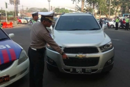 Kasatlantas Jakarta Timur AKBP Sutimin melakukan pengalihan mobil terdampak ganjil genap di Panjaitan, Rabu (18/7/2018)