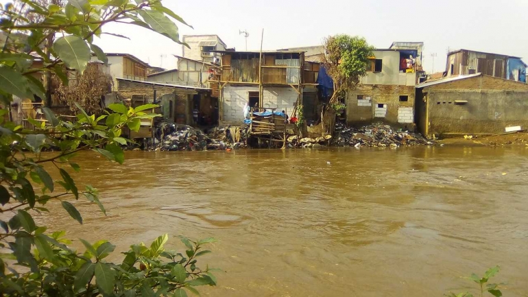 rumah-rumah di bantaran kali di bukitduri ini sudah biasa dengan banjir. kumuh dan terkesan jorok.