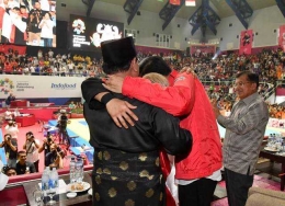 Hanifan peraih medali emas cabor silat Asian Games 2018 memeluk Jokowi dan Prabowo (news.okezone.com).