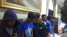 Lima orang pria berkostum ciri khas suporter Persib Bandung digelandang ke Mapolrestabes Bandung, Minggu (23/9) malam. Mereka terlibat dalam pengeroyokan hingga menewaskan seorang warga Cengkareng yang diduga suporter Persija Jakarta. Sumber (http://banjarmasin.tribunnews.com) 