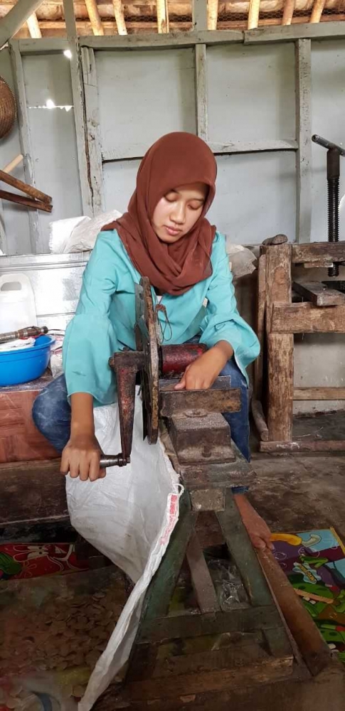 Imas Mintarsih saat mengiris kerupuk jengkol sebelum dijemur. (Foto: koleksi Imas Mintarsih)