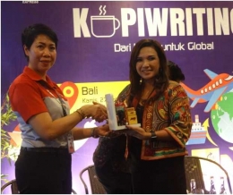 A.A.A. Mas Utari Noviyanthi selaku pemilik Beehandycraft Bali menerima plakat dari Kepala JNE Denpasar. Ibu Alit Septiniwati / dokpri