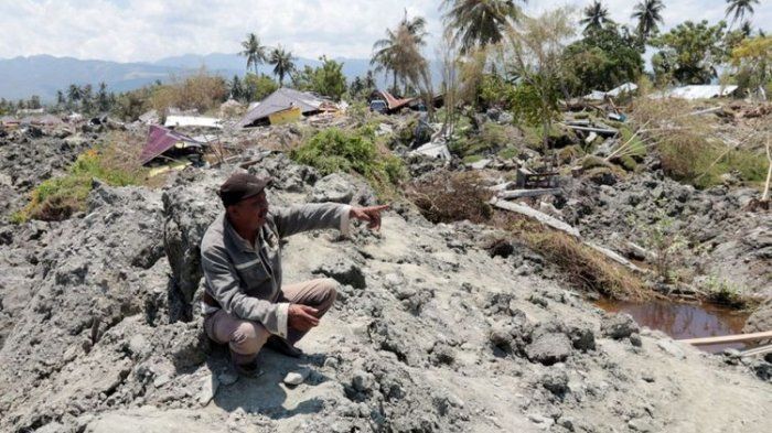 Seorang warga Palu menunjukkan sebuah rumah beton yang digulung lumpur yang keluar dari perut bumi dan berpindah ratusan meter di Kelurahan Petobo, Kecamatan Palu Selatan, Kota Palu, Sulawesi Tengah, pasca-gempa bermagnitudo 7,4 (KOMPAS.com/ROSYID A AZHAR)