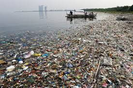 Nelayan yang akan melaut melewati sampah yang mengambang di lepas pantai Teluk Manila, Filipina pada 8 Juni 2013 (Sumber: news.nationalgeographic.com/Erik De Catro/Reuters)