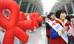 Ilustrasi: Relawan Palang Merah China pada acara kesadaran AIDS di Hari AIDS Sedunia 1 Desember 2009 di stasiun kereta api selatan Beijing, untuk menyerukan dukungan pemerintah yang lebih baik untuk pengidap HIV/AIDS di China. (Sumber: theepochtimes.com/ AFP/Getty Images)
