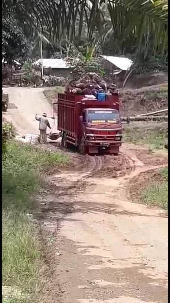 Uyun mengemudi truknya melewati jalan rusak di Desa Muara Hemat Kecamatan Batang Merangin. screenshoot video kiriman Uyun Koto