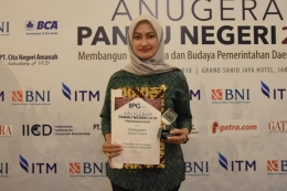 Bupati Luwu Utara, Indah Putri Indriani saat memperlihatkan penghargaan Anugerah Pandu Negeri 2018