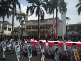Salah satu iring-iringan dalam Parade Surabaya Juang yang membawa photo para pahlawan nasional dengan bentangan bendera Merah Putih raksasa (Dok. Pribadi)