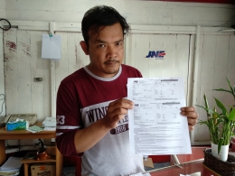 Arif, karyawan JNE Cabang Takengon memperlihatkan arsip faktur pengiriman bubuk kopi dari Takengon ke kota-kota di Pulau Jawa (Foto: Syukri MS)