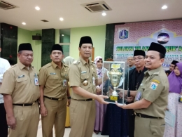 Camat Gropet H. Achmad Sajidin menera trofi juara umum STQ ke-25 tingkat Kota yang diserahkan langsung oleh Walikota Administrasi Jakarta Barat H. Rustam Effendi