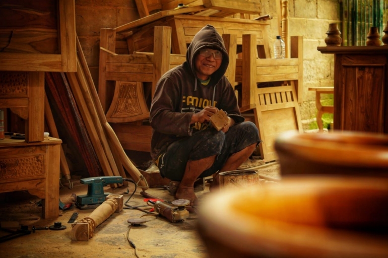 Seorang pekerja di industri kerajinan kayu jati tengah merampungkan proses produksi. Sumber: dokumen pribadi