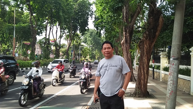 Suasana lalu lintas di salah satu jalan yang penuh pepohonan di Kota Surabaya