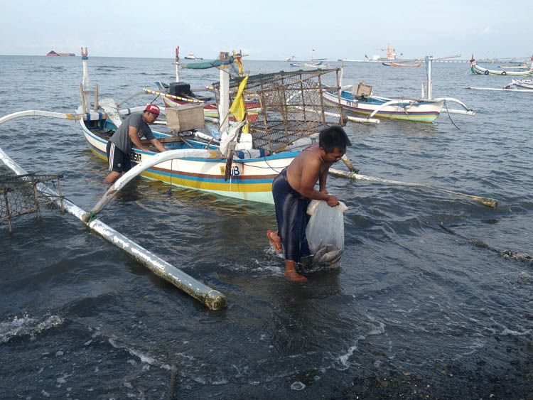 Nelayan dengan hasil tangkapannya dan perahu fiber Pantai Binor (dok. pribadi)