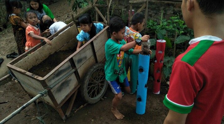 Pemasangan vertikultur bersama anak-anak di Dusun Deles (Sumber: dokumentasi pribadi)