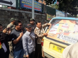 tampak sejumlah Anggota Bawaslu Depok, petugas Satpol PP dan DISHUB Kota Depok melepaskan APK yang di pasang pada Angkutan Umum di Kota Depok hari ini (18/12/18)