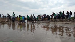 Para relawan dengan senang hati berjalan kaki sejauh lebih dari satu kilometer untuk mencapai lokasi penanaman mangrove. (dok.Nia Nurdiansyah).