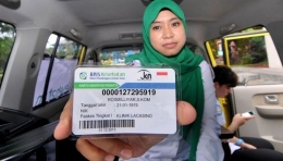 Seorang petugas menunjukan bentuk kartu Jaminan Kesehatan Nasional di RS Fatmawati, Jakarta (01/01). Mulai 1 Januari 2014, pemerintah meluncurkan program Jaminan Kesehatan Nasional (JKN), JKN merupakan program jaminan kesehatan yang akan diterapkan secara nasional dan ditangani oleh Badan Penyelenggara Jaminan Sosial (BPJS). TEMPO/Dasril Roszandi