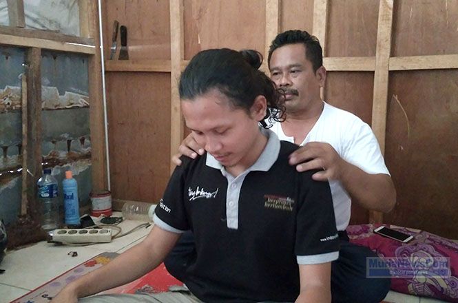 Capres guyonan Nurhadi memijat pasiennya saat ditemui di kios pijat kesehatan di Pasar Brayung, Kecamatan Mejobo, Kabupaten Kudus, Jumat (4/1/2019). (murianews.com/Dian Utoro Aji)