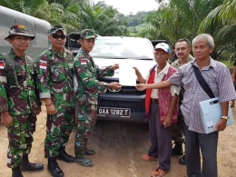 SERAHKAN WARGA - Anggota TNI (kiri) menyerahkan lima warga Malaysia dan barang bukti yang sebelumnya diamankan kepada perwakilan pemerintah Malaysia setempat. (Foto : Dokumen Penerangan Korem 121/ABW)