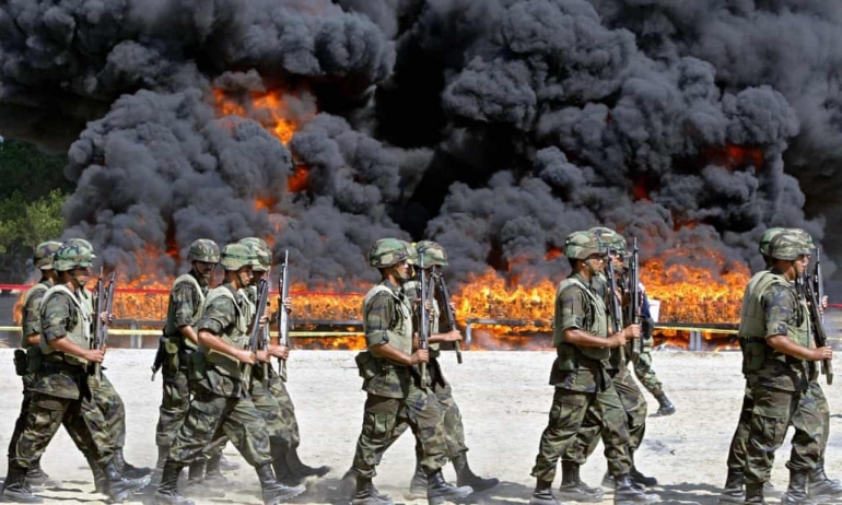 Militer Meksiko berjalan di sekitar lokasi pembakaran 20 ton kokain yang siap diselundupkan ke Amerika (Sumber: theguardian.com).