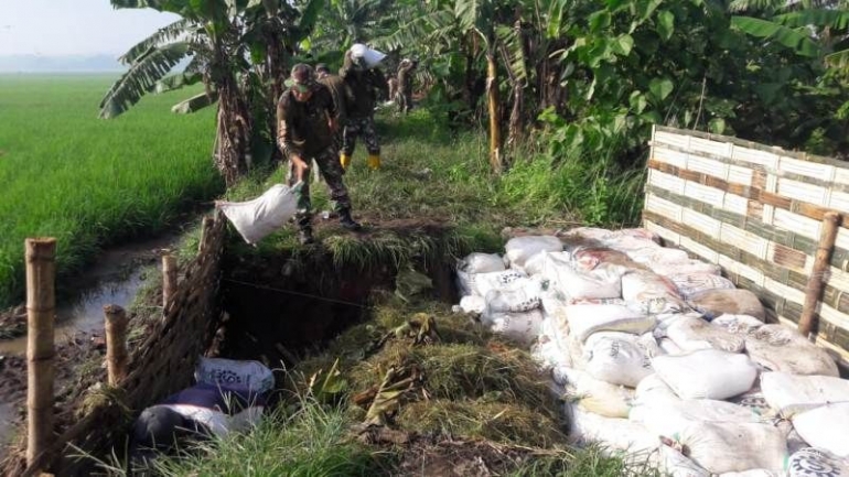 Anggota Koramil 0815/12 Ngoro Bersama Perangkat Dan Warga Desa Wonosari Saat Memperbaiki Tanggul Jebol (Dokpri)i)