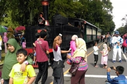 IKON CFD: Sejumlah warga tampak mengabadikan momen saat kereta melintas di tengah-tengah CFD di Jalan Slamet Riyadi, Solo, Minggu (11/3). (Ari Purnomo/JawaPos.com)