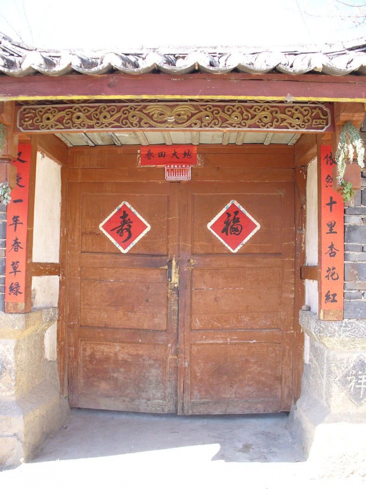 Syair Tahun Baru dalam warna merah menglilingi pintu rumah Tionghoa. (Gambar dari Chrislb).
