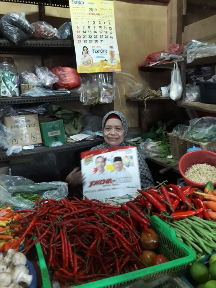 Salah satu pedagang pasar menerima kalender dan menyatakan bersedia mendukung Jokowi-KH Ma'ruf Amin. Foto: BP/dok.
