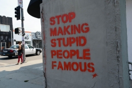 Please, Stop Making Stupid People Famous! | ilustasi. Sebuah mural bertuliskan 