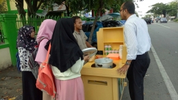 Alhlul Muchtar dan Jasuke, saat ia sedang menjajakan usahanya dan melayani pembeli didepan sekolah MAN 1 Banda Aceh (dokpri) 