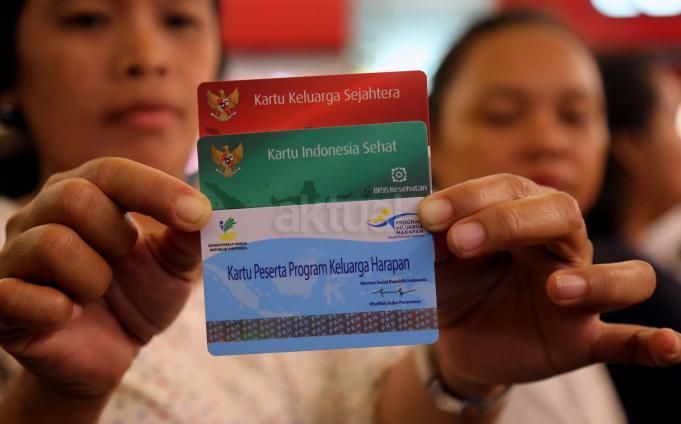Seorang warga menunjukan tiga kartu ( Kartu Keluarga Sejahtera, Kartu Indonesia Sehat, Kartu Peserta Program Keluarga Harapan) pada saat pemberian bantuan sosial kepada Program Keluarga Harapan (PKH) di Jakarta, Rabu (27/4/2016)