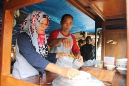 Daniyah dan Tarsono, sibuk meladeni pelanggan baksonya. (Foto: Gapey Sandy)