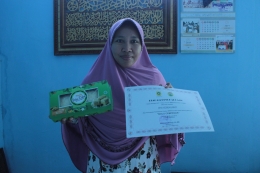 Foto Bu Ani Kurniasih dengan Produkt Bolu Cempedak dan sertifikat penghargaan yang pernah diraih/dokpri