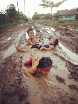 Anak-anak bermain lumpur di jalanan rusak (Gambar: facebook.com/muadz.chalik)