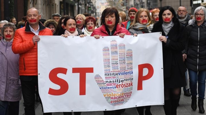 Peserta aksi dan simpatisan membawa spanduk bertuliskan ”STOP” dalam peringatan Hari Anti-kekerasan terhadap Perempuan, di Budapest, Hongaria, Jumat (23/11/2018). (AFP/ATTILA KISBENEDEK)