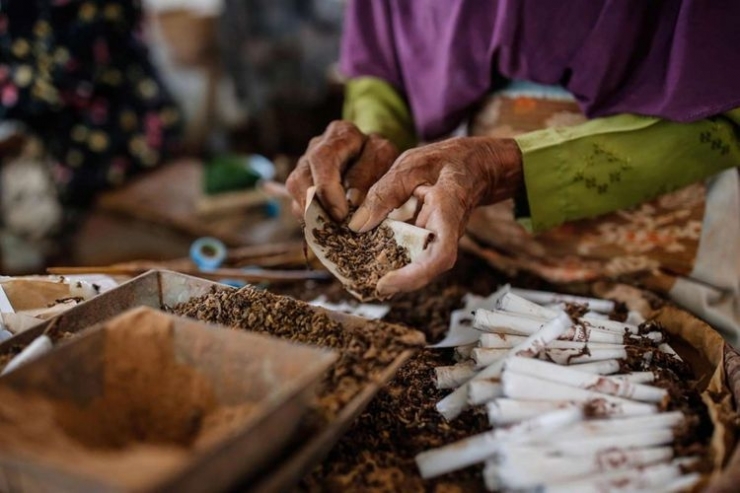 Pekerja menyelesaikan pembuatan rokok sintren di Perusahaan Rokok Klembak Menyan di Gombong, Kebumen, Jawa Tengah, Sabtu (21/10/2017). Distribusi rokok sintren meliputi daerah Kebumen, Kroya, Purwokerto dan Gombong, yang satu bungkusnya dijual seharga Rp 2100 dengan isi 10 batang. (KOMPAS.com/GARRY ANDREW LOTULUNG)