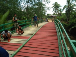Satgas TMMD Ke-104 Kodim 0913/PPU bersama warga sedang mempercantik jembatan yang menghubungkan Warga Desa Argomulyo dan Desa Tengin Baru