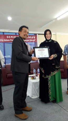 Direktur Politeknik Kutaraja, Supriyanto, SP.,M.Si. menyerahkan piagam penghargaan kepada Illiza Sa'aduddin Djamal pada Seminar Keuangan yang diselenggarakan oleh Himpunan Mahasiswa Program Studi Manajemen Keuangan Sektor Publik (MKSP) Politeknik Kutaraja, Sabtu (23/03/2019) - dokpri