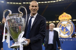 Pelatih Real Madrid Zinedine Zidane mengangkat trofi Liga Champions seusai mengalahkan Juventus pada final di Stadion Millenium, Sabtu (3/6/2017). (AFP/FILIPPO MONTEFORTE)