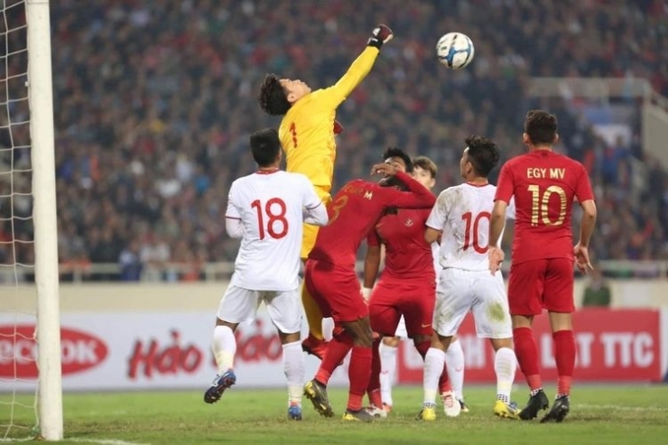 Duel udara dua pemain timnas u-23 Indonesia (merah) dengan pemain Vietnam pada laga kedua Grup K Kualifikasi Piala Asia U-23 di Stadion My Dinh, Hanoi, Minggu (24/03/2019).(VNEXPRESS/ XUAN BINH)