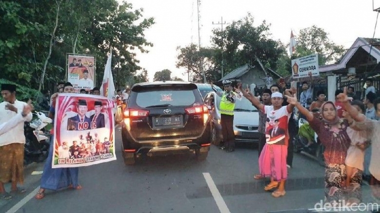 Sambutan massa pendukung Prabowo-Sandi kepada iring-iringan rombongan Kyai Ma'ruf Amin yang akan berziarah di Madura (detiknews.com).