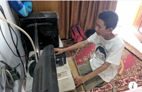 Putra sedang beraksi dengan komputernya. foto : kompas.com/jimmy ramadhan azhari