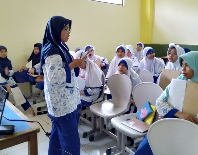salah seorang siswa membacakan hasil karyanya di depan kelas