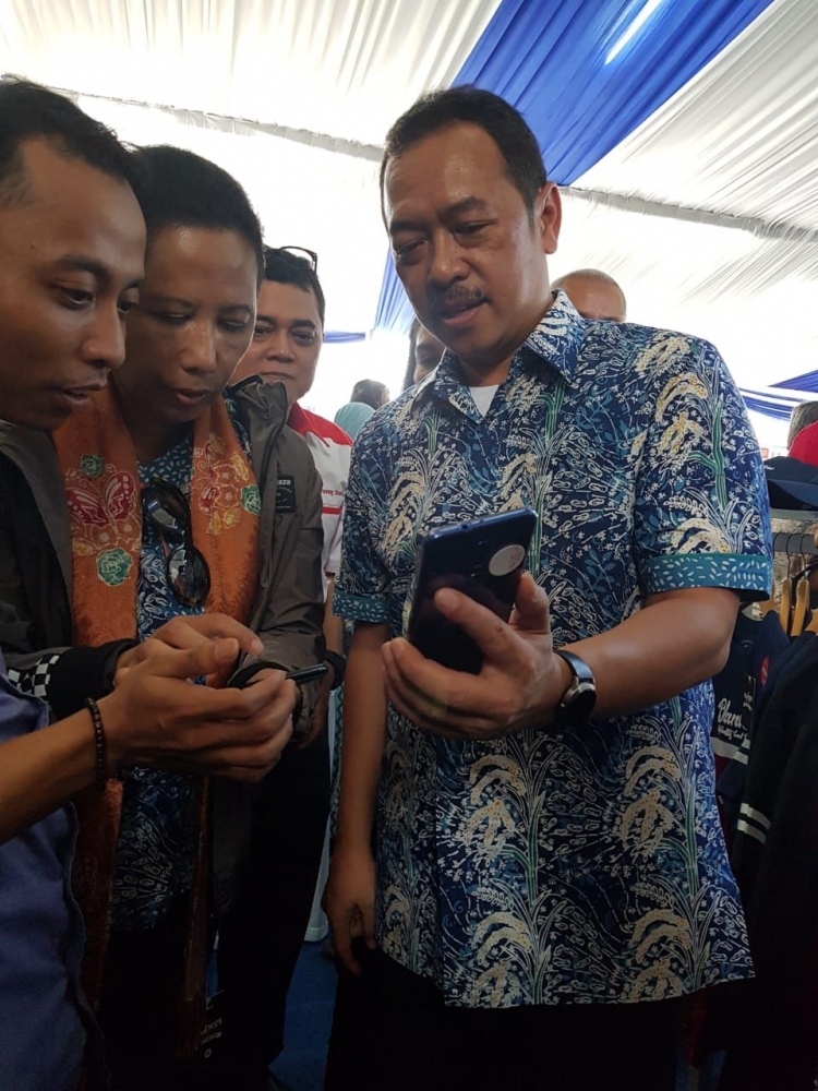 Rini Soemarno (tengah, mengenakan batik) bersama Fajar Harry Sampurno (kanan) menjelaskan kepada salah satu pemilik UKM mitra binaan BUMN tentang transaksi Linkaja