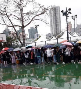 Suasana antrian memilih dalam guyuran hujan di TPS Wan Chai (Dok. Purwanti)