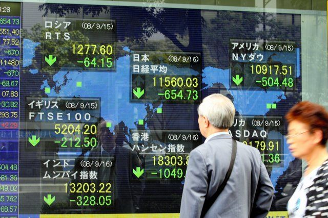 Seorang Bapak sedang melihat harga saham yang turun saat krisis finansial global (asahi.com)